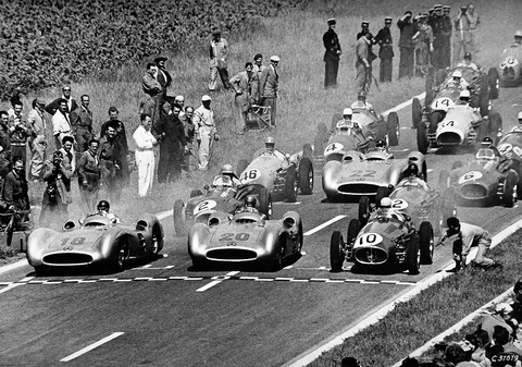 Großer Preis von Frankreich in Reims, 4. Juli 1954: Im Mercedes-Benz W 196 R Stromlinienwagen der spätere Sieger Juan Manuel Fangio (Startnummer 18), daneben Karl Kling (Startnummer 20), dahinter Hans Herrmann (Startnummer 22). French Grand Prix in Reims, July 4, 1954: Juan Manuel Fangio, who was to win the race, at the wheel of the Mercedes-Benz W 196 R streamliner (start number 18), next to him Karl Kling (start number 20), and behind them Hans Herrmann (start number 22).