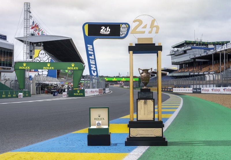 24 heures du Mans - Rolex watch and Le Mans trophy with the grand stand in the background